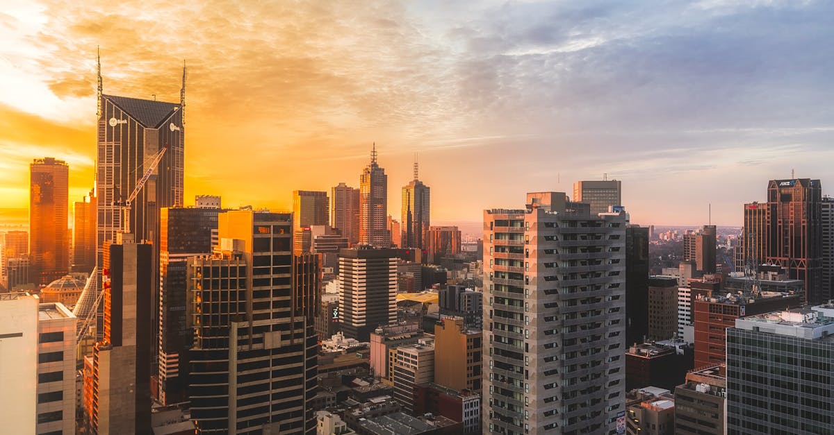 Stunning view of Melbourne's skyline at sunset, capturing modern skyscrapers and warm sky.